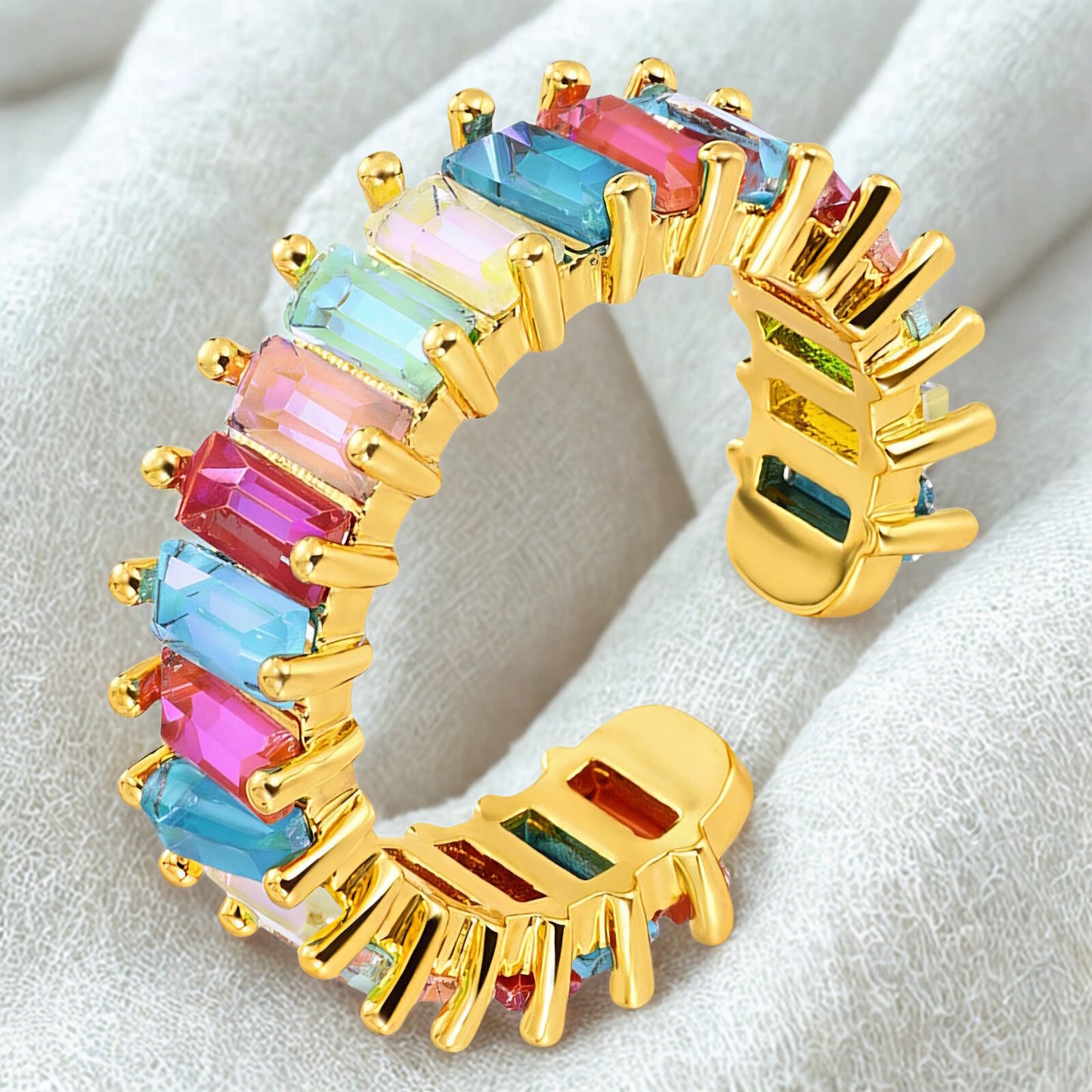 Gold ring with colorful gemstones on a white background