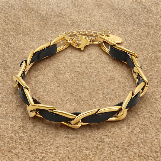Gold and black chain bracelet on a beige background
