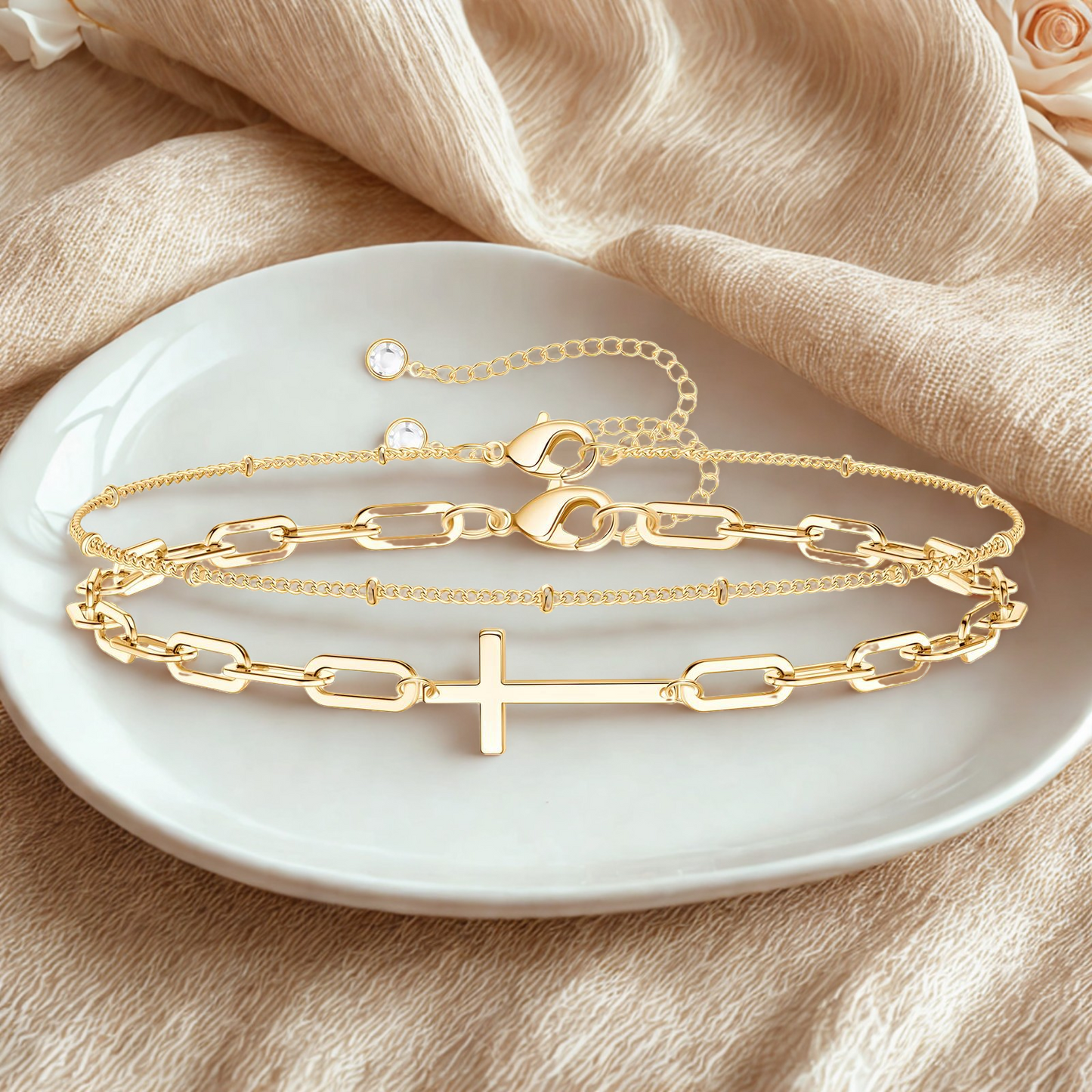 18K gold bracelet set with cross charm displayed on a neutral fabric background – Drawn Bracelet Set by 31:10 Jewelry