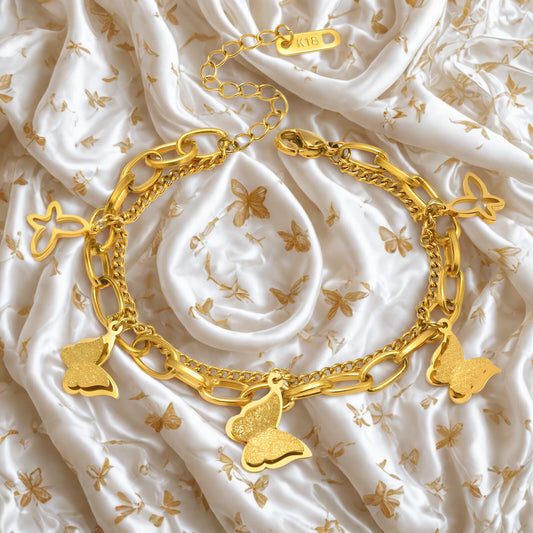 Gold butterfly charm bracelet with textured and openwork butterflies on linked chain.