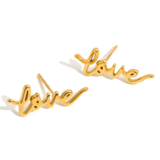 Gold 'love' earrings on a white background