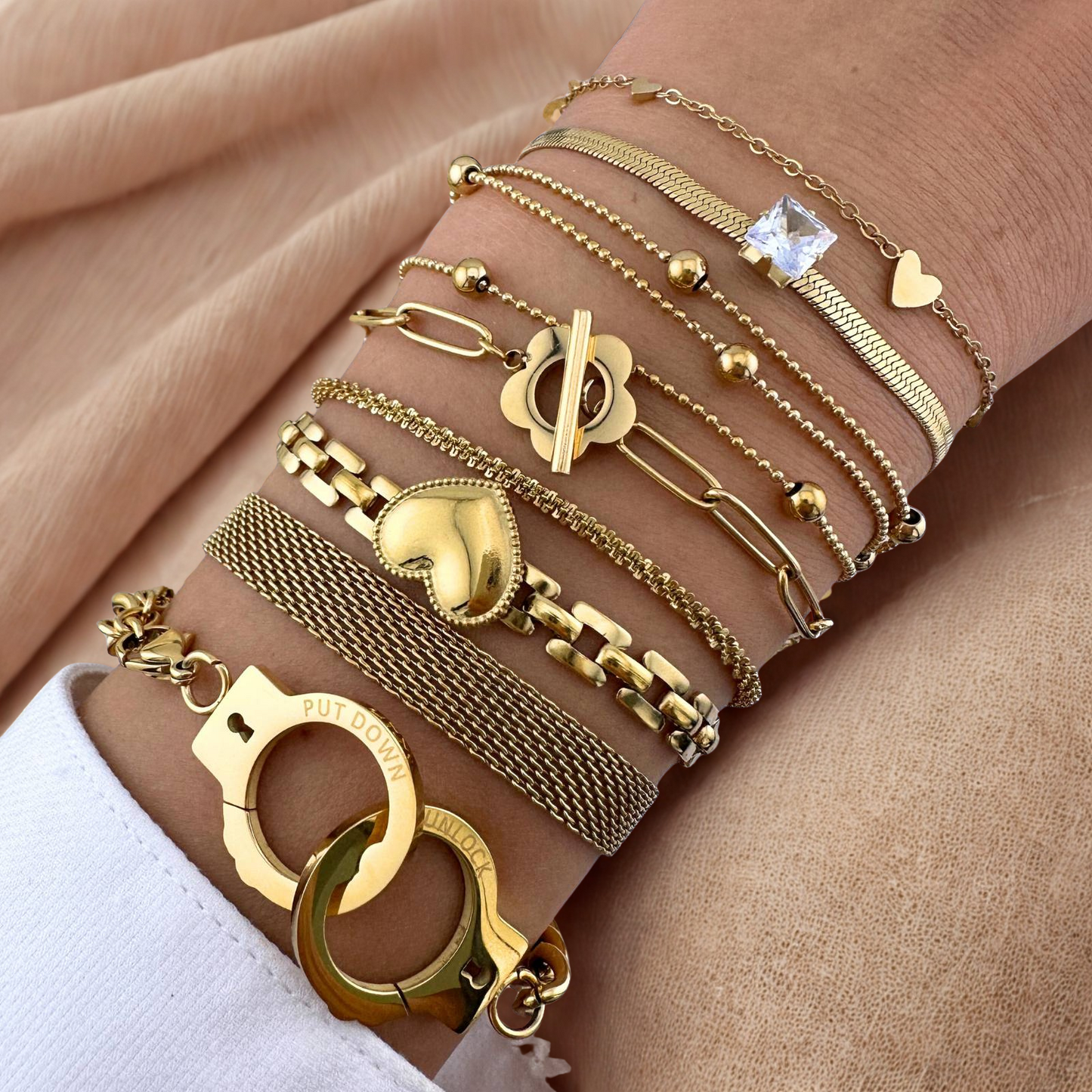 Gold bracelets on a wrist with various designs