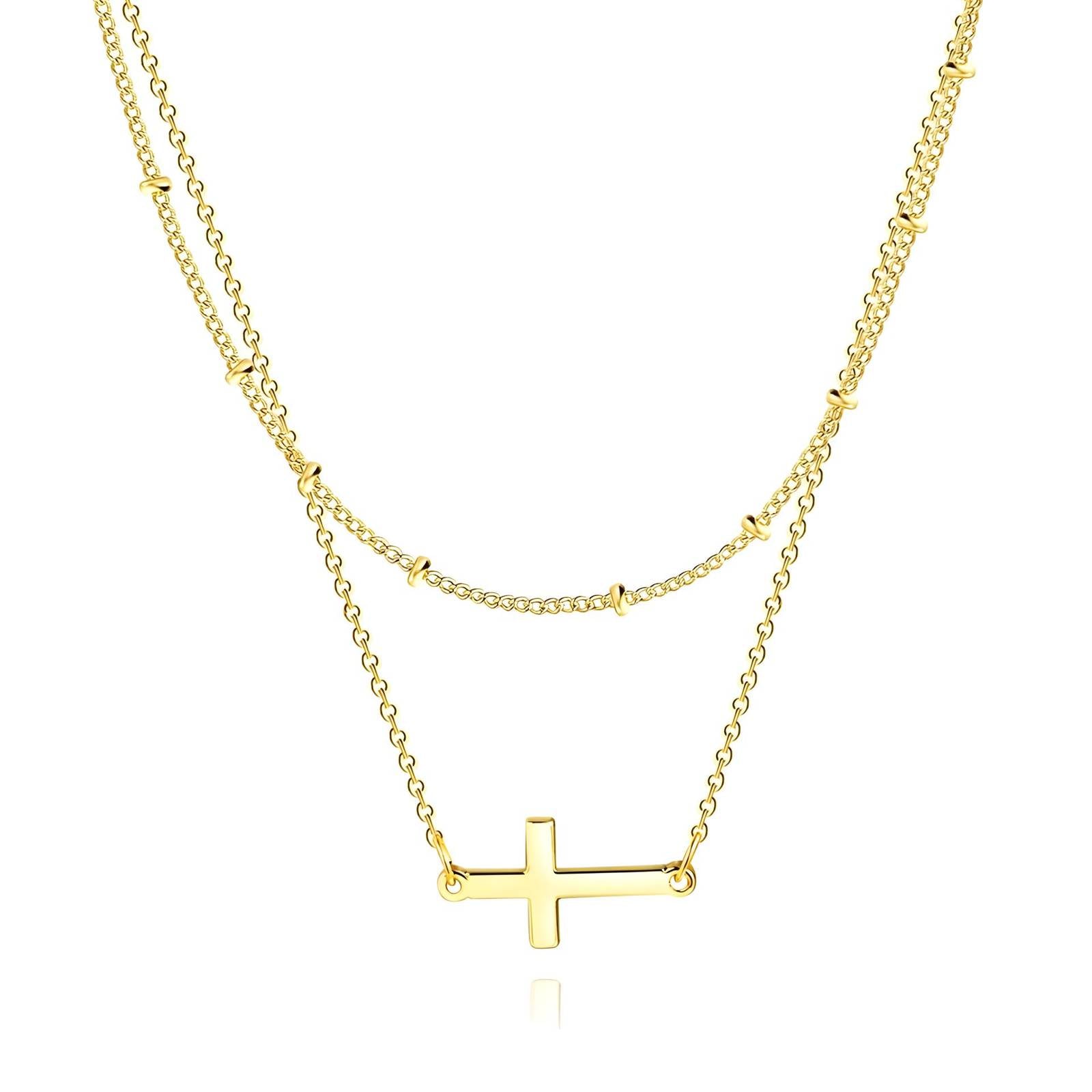 Gold layered necklace with sideways cross pendant, minimalist Christian jewelry.

