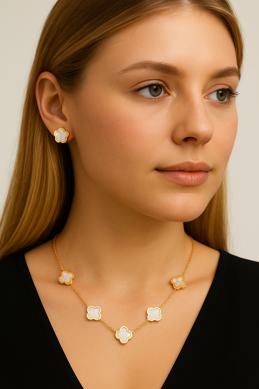 Woman wearing a gold necklace with floral pendants against a neutral background