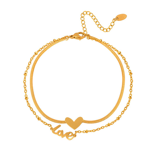 Gold bracelet with 'love' and heart design on a white background