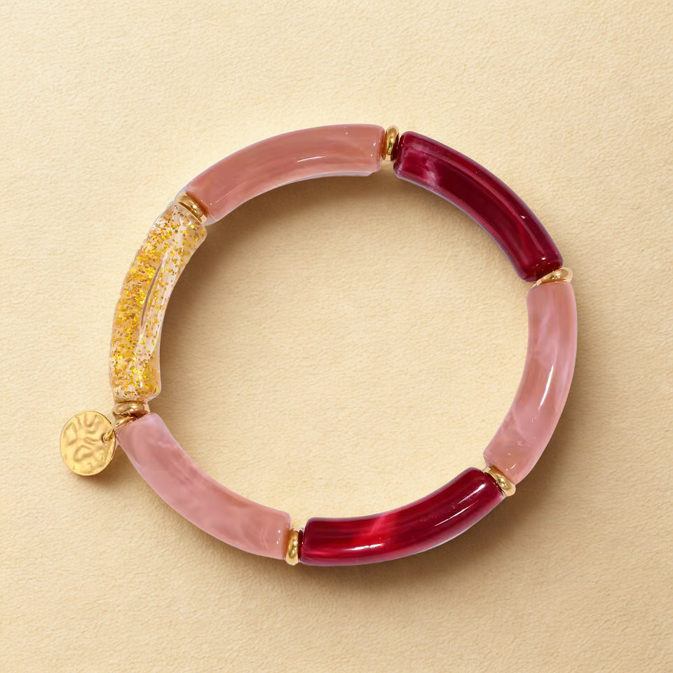 Bracelet with pink and red beads on a beige background