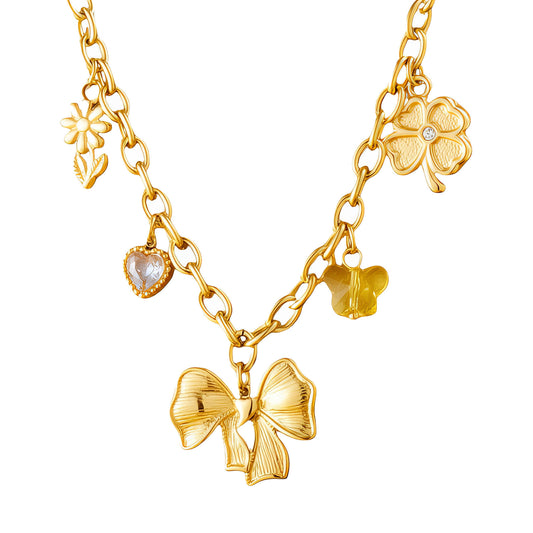 Gold charm necklace with bow, flower, heart, and clover pendants.