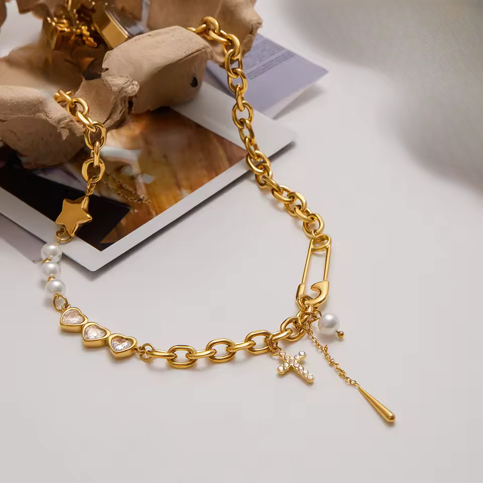 Gold chain bracelet with various charms on a light background