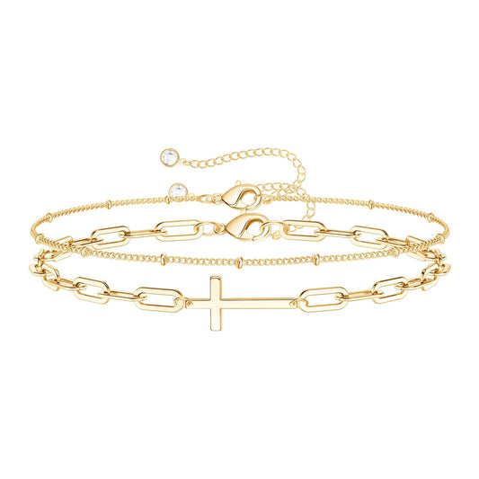 18K gold bracelet set with cross charm displayed on a neutral fabric background – Drawn Bracelet Set by 31:10 Jewelry