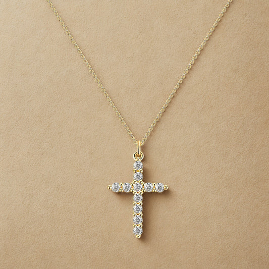 Gold cross necklace with diamonds on a beige background