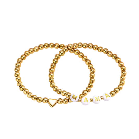A sweet pairing of two stretch bracelets: one with a polished gold heart, the other spelling out MAMA in soft white beads. This set is lightweight, meaningful, and perfect for everyday wear. A simple way to honor the love that beats at the center of motherhood.