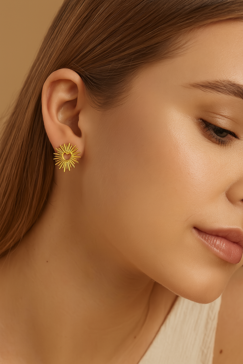 Close-up of a woman wearing a gold earring with a heart design.