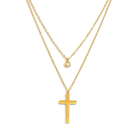 Gold cross necklace with a smaller round pendant on a white background