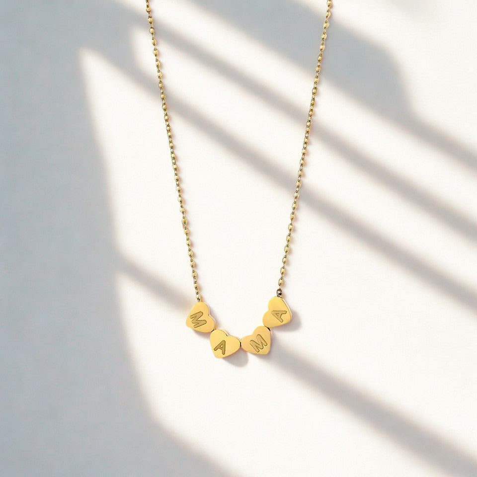 Gold mama necklace with heart-shaped letters on a delicate chain