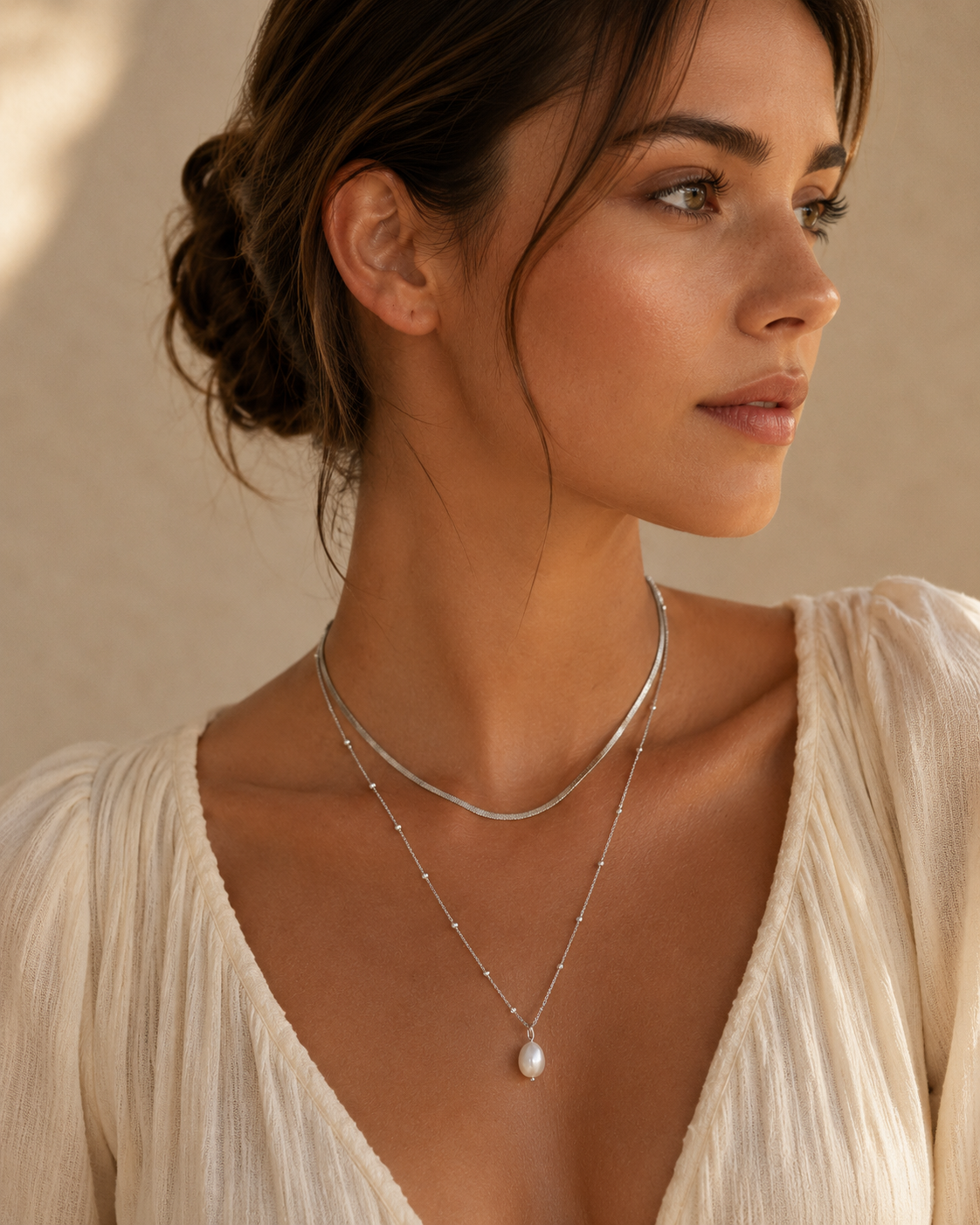 Woman wearing a pearl necklace against a neutral background