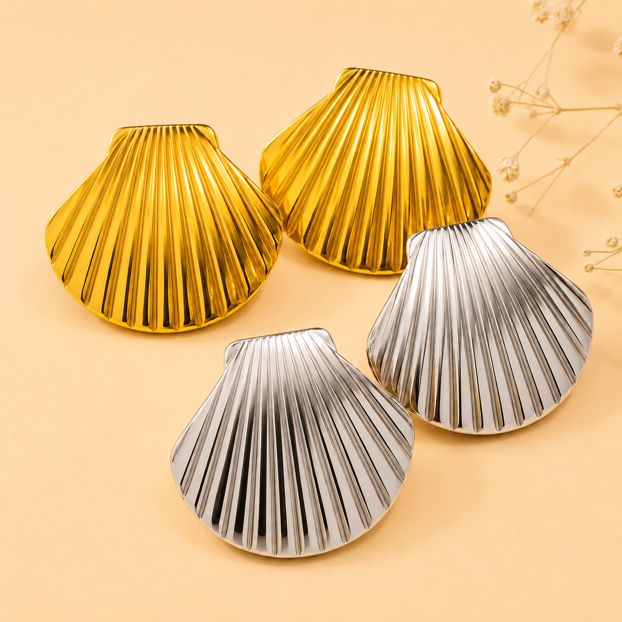 Gold and silver shell-shaped objects on a beige background