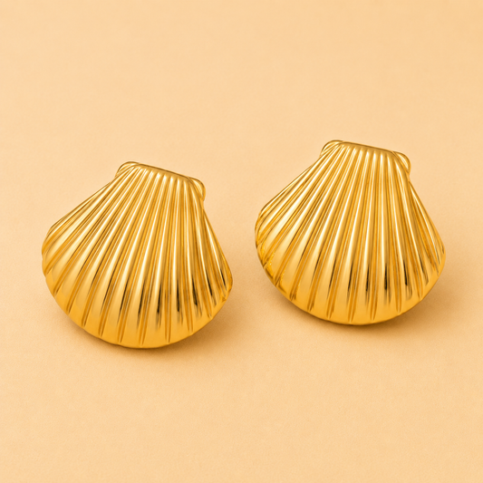 Large gold shell statement earrings with a polished coastal-inspired design.