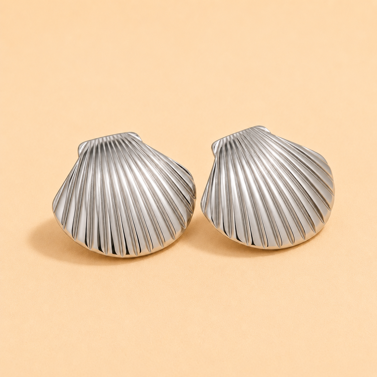 Large silver shell statement earrings with a polished coastal-inspired design.