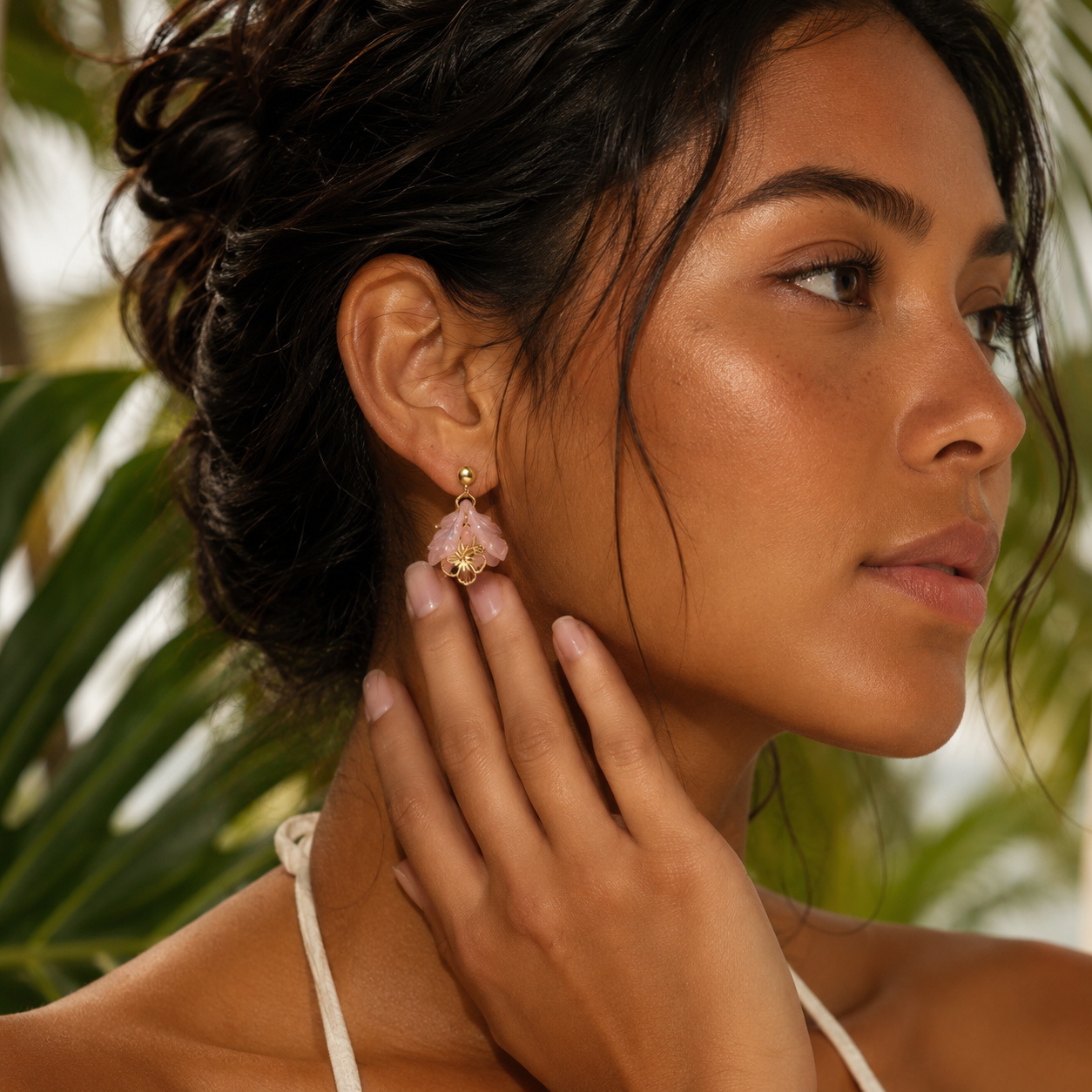 Woman wearing a pink earring with a blurred green background
