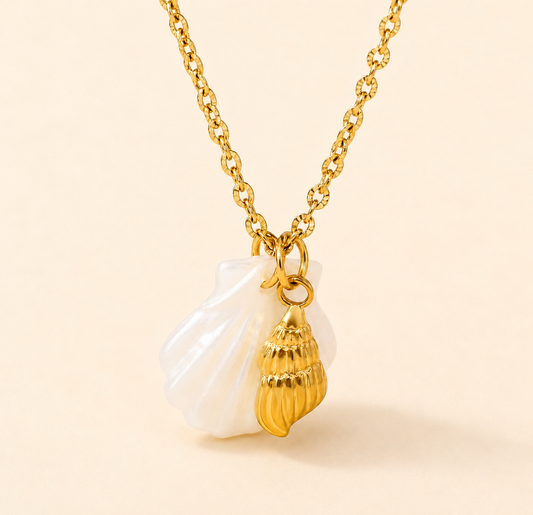 Gold necklace with a shell pendant on a beige background