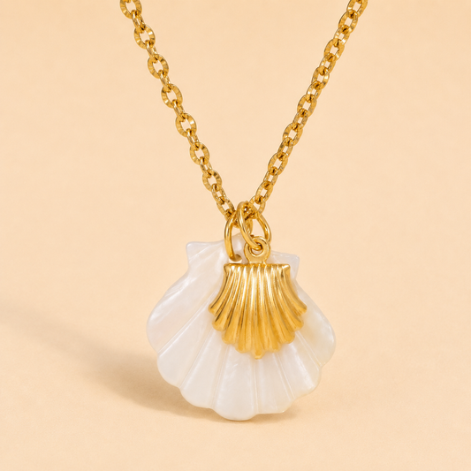 Gold and white shell pendant necklace on a beige background