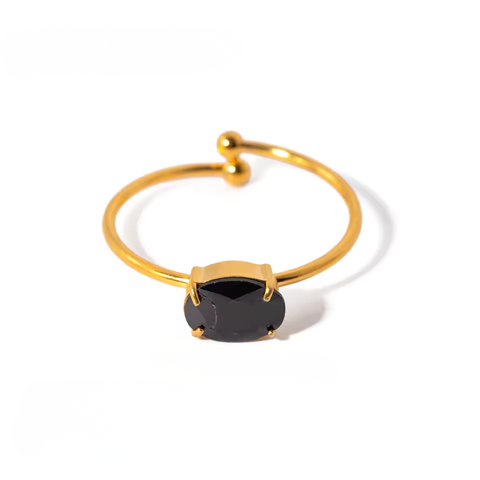 Gold ring with a black gemstone on a white background