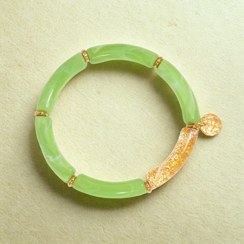 Green jade bracelet with gold accents on a light green background
