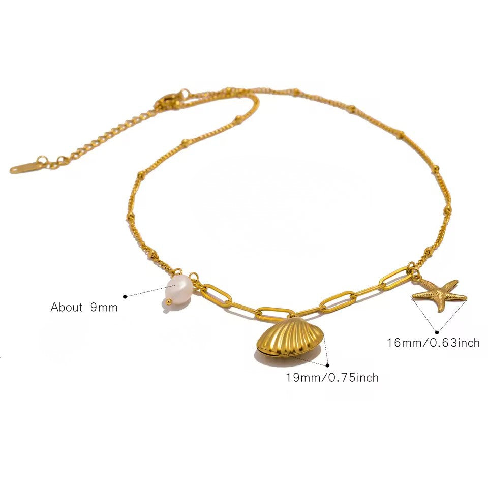 Gold chain necklace with shell, starfish, and pearl charms on a white background