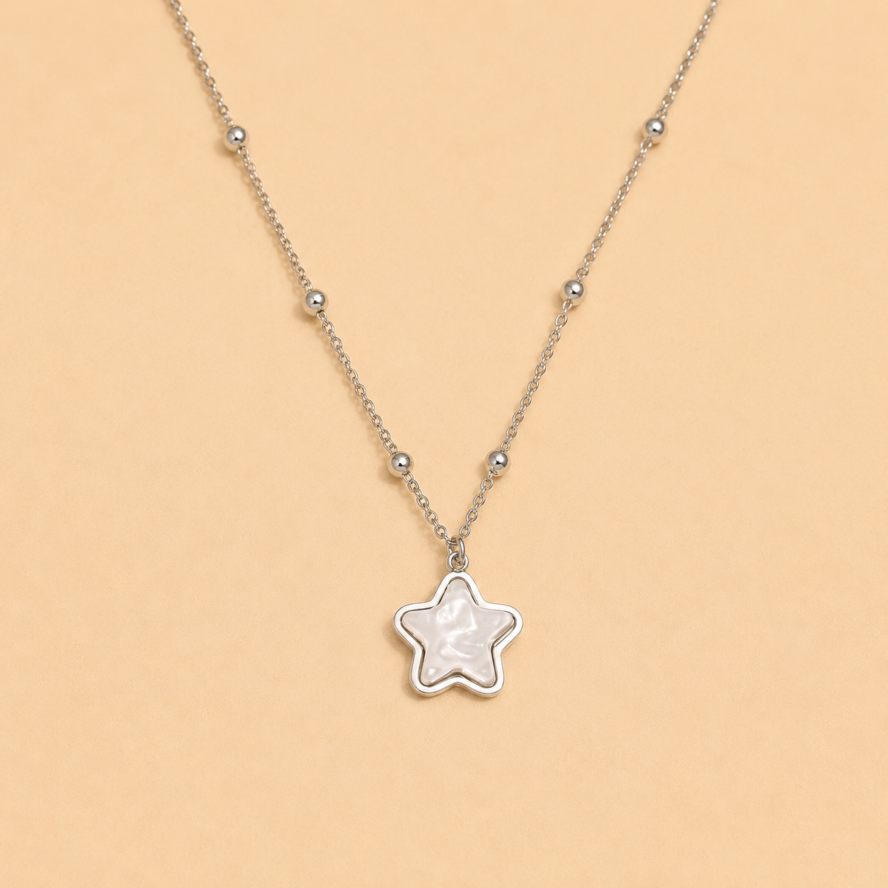 Star-shaped pendant necklace on a beige background