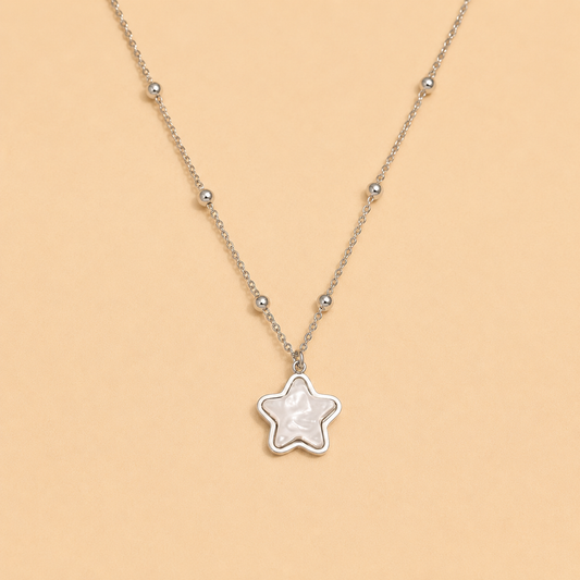 Star-shaped pendant necklace on a beige background