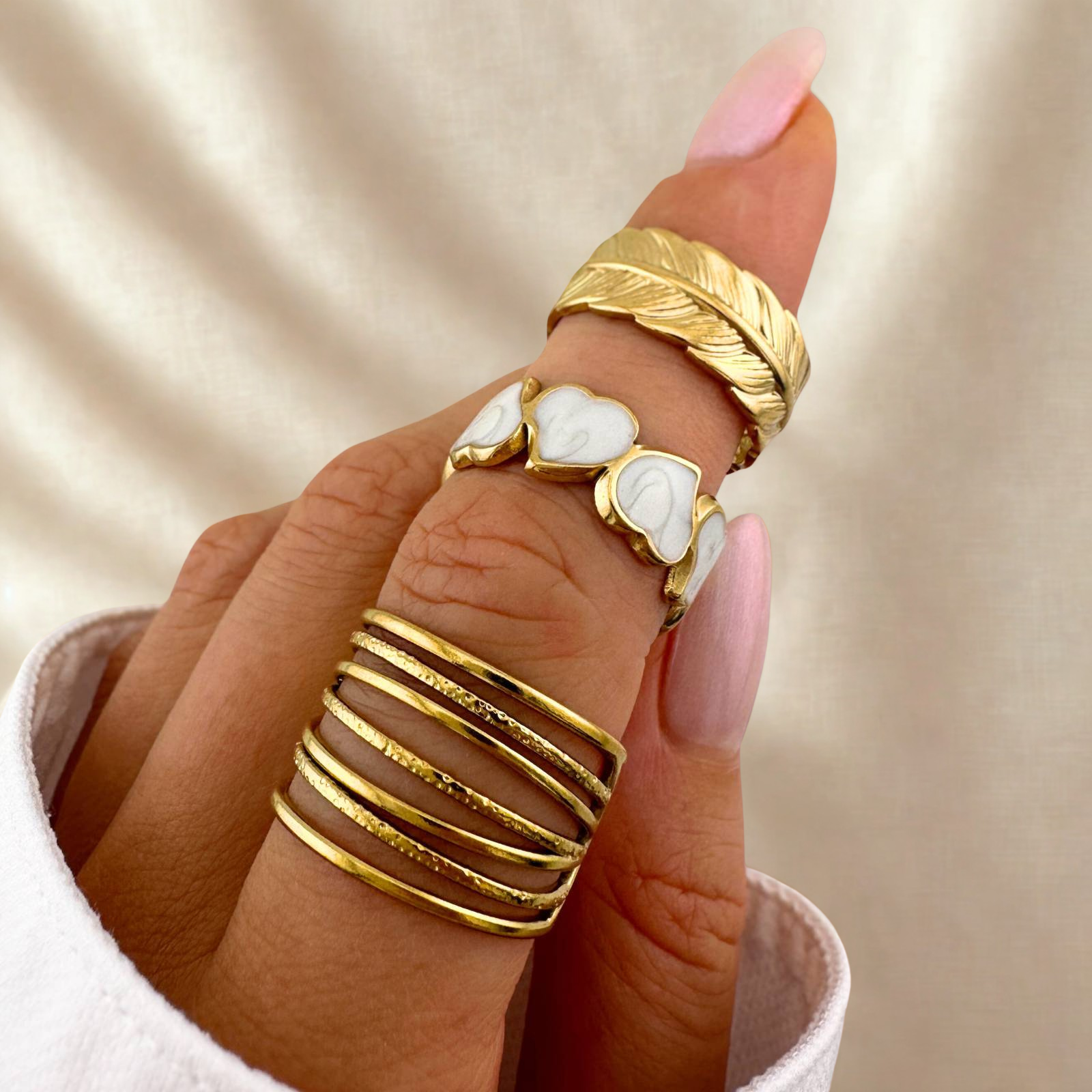 Adjustable gold ring with white enamel heart design.