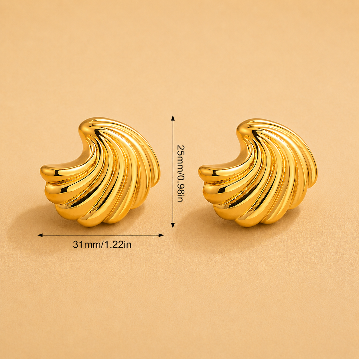 Gold sea shell earrings with measurements on a beige background