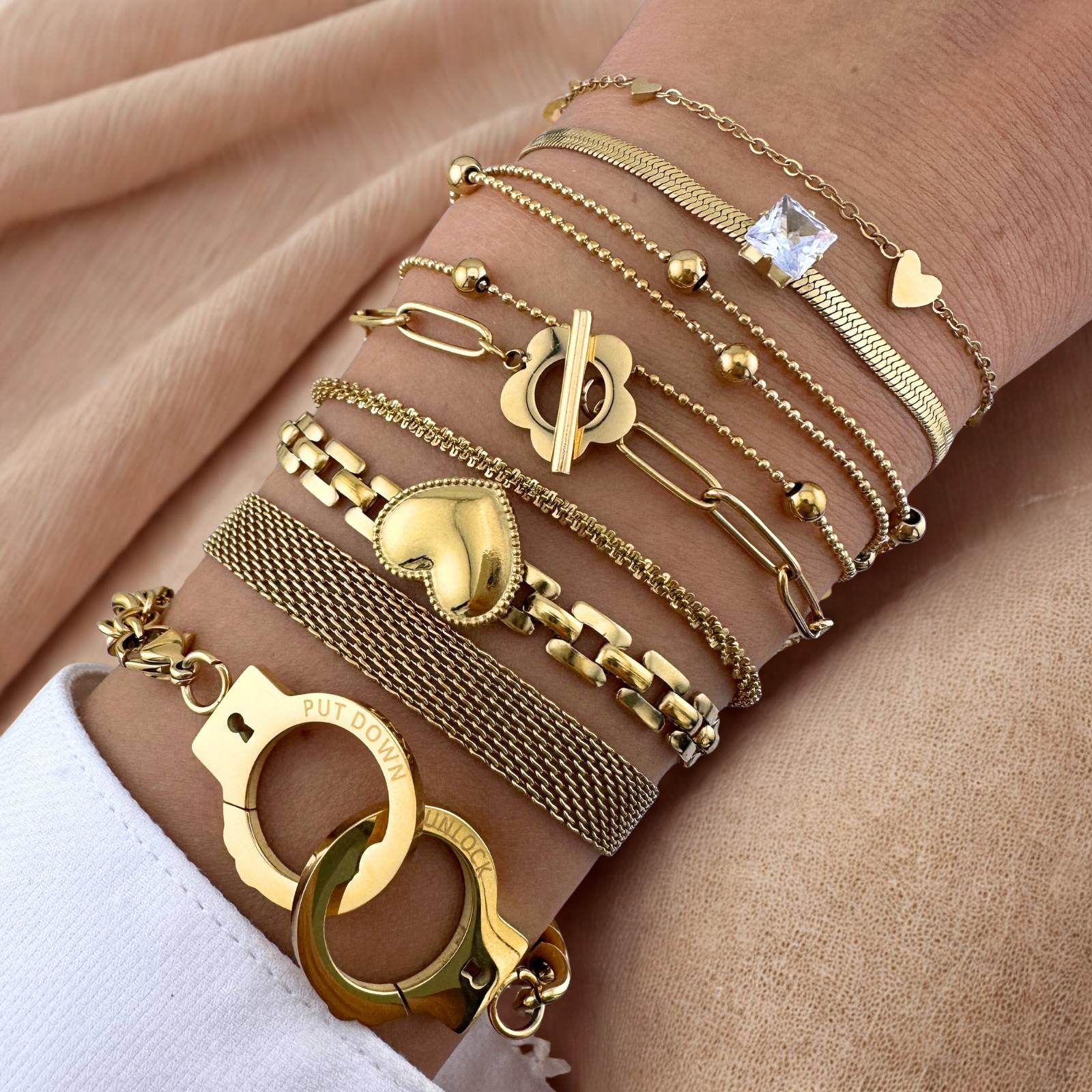 Gold bracelets on a wrist with various designs